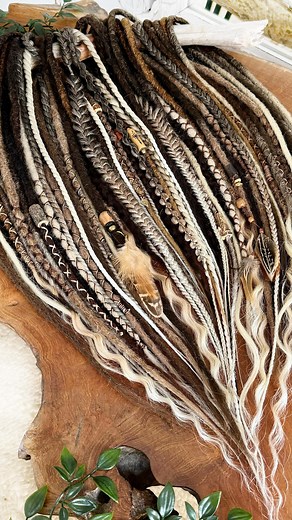 Who is ready for the next level in their Hair Story? 😍 I just finished this full set, “the Venturer”, temporary dreadlock extensions with high quality synthetic hair & wool. She is beautifully adorned with all sorts of handmade beads, wraps, charms and feathers. This set is enough for a full head install. ✨✨ Temporary Dreadlock Extensions are installed by braiding them in. They can stay in for a maximum of 2 months and be reinstalled again. The extensions can last for years when well taken care