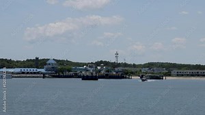 POV-Aboard the ferry approaching the Lewes, Delaware ferry dock from Cape May, New Jersey after crossing Delaware Bay with small boat motoring past.