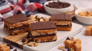 Nougat, caramel, peanuts, and chocolate… all from your own kitchen! 🤤 Watch how easy it is to make homemade Snickers! Say RECIPE and I will send you this recipe! #HomemadeSnickers #CandyLoversUnite https://www.eatingonadime.com/homemade-snickers/ | Eating on a Dime