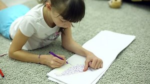 clip-1019061391-girls-draw-markers-album-lying-on-floor