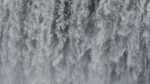 Immense waterfall captured in stunning detail. Tons of water, torrential flow cascading down, creating a mesmerizing and intricate texture. Display of nature's power. Real time 4k stock footage.