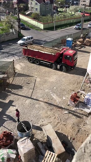 Red Dump Truck in Action at Construction Site