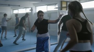 Teen girls sparring at boxing class, children group practicing kicks in gym, handheld shot. Boxer training kids in combat sport club, boys and girls workout