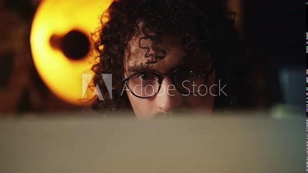 Concentrated male programmer in eyeglasses working on retro computer, 80s style