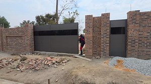 This Sliding gate is cladded with Alu-composite, or Aluminium Composite Material (ACM). ACM is a type of panel made of two thin aluminium sheets bonded to a core polyethylene material. This composite structure makes it lightweight, flat, strong, and flexible, with common uses in construction for exterior and interior cladding, signage, and displays. ACM is found in various colours and finishes and its fine finish and posh look makes it the most sought for material for these various uses. For a q