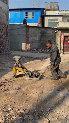 The process of chiseling a cement floor using this propelled automated tool.