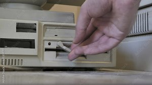 The inserting an old-style 5.25, 3.5 Inch floppy disks. Old-style 1980s - 1990s computer