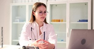 Professional doctor talks with patient via online video chat on laptop. Female specialist tells about diagnosis and treatment slow motion