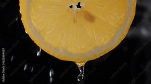 Fresh lemon Slice. Juicy lemon. Squeeze out juice. Water dripping on a lemon slice. Smoke on a dark background