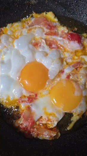 Fried eggs with tomatoes in olive oil. Breakfast.