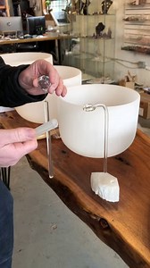 ''PENDULE CHANTANT THÉRAPEUTIQUE' Le pendule chantant est l'un des instruments développés et fabriqués au Québec. La note du pendule est composée d'une tige pleine en cristal de quartz soutenue à un prisme de cristal de verre par un fil en fluorocarbone. La percussion du maillet sur la tige génère des sons de hautes fréquences harmonieuses d'une durée supérieure à une minute. Le pendule chantant peut être joué en mains ou déposé sur son socle. Ce dernier est composé de cristal de sélénite et d'a