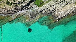 Rocky coast with azure sea in La Pelosa - Sardinia, Italy.