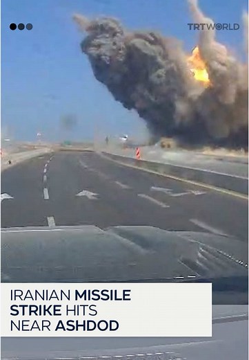 Title: Iranian missile strike hits near Israeli port city of Ashdod Caption: Dashcam footage shows the moment an Iranian missile struck near a highway in Ashdod, Israel. Iran launched missile attacks on Israel on June 23, with a massive explosion reported in the Israeli port city following the fresh barrage of Iranian missiles.
