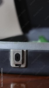 A Man Opens An Old Vintage Business Suitcase. A Black Briefcase Is Lying On A Wooden Table. Vertical.