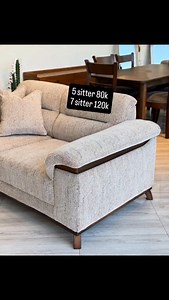 This modern fabric sofa combines comfort, elegance, and timeless design. It features a soft, textured beige upholstery paired with beautiful dark wooden trims that highlight the armrests and base, giving it a warm and sophisticated finish. The plush cushions and deep seating provide exceptional comfort, making it perfect for both relaxing and entertaining. The sofa stands on strong, tapered wooden legs that add stability and a clean contemporary look. Its neutral colour blends effortlessly with 