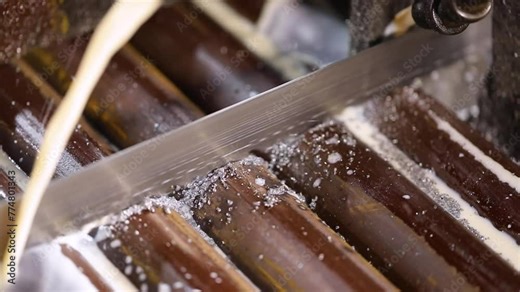 close up of Metal round bar cutting process in a machine for forging of alloy steel component pieces in a factory