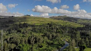 Beautiful green hills and river with trees, cinematic aerial of Papua New Guinea landscape