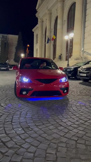 Stunning Red Sedan with Blue Underglow in Urban Night