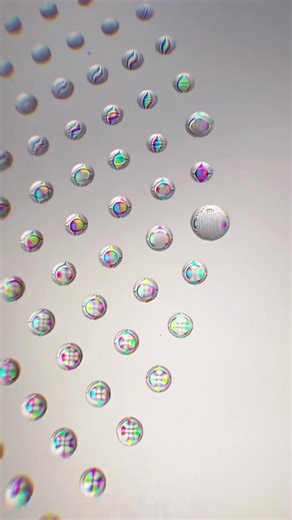 Using an #axidraw plotter to make tiny water droplets on an iPad screen creates tiny maginifying spheres and an amazing color show #plotter #plotparty #rainbow #macro