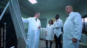 The supervisor explaining to the engineers the plan from the whiteboard in the office.