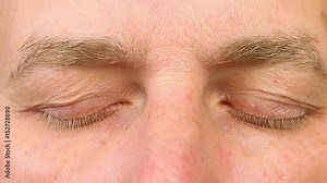 Sleeping adult man open his eyes. Extreme close-up view. Human eyes fast open up. REM rapid eye movement. See dreams sleep and wake up rapidly. Caucasian male face close open eyes. Ophthalmology.