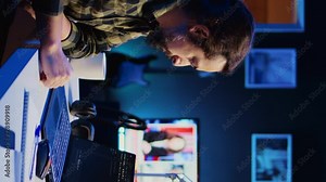 Vertical video Skilled computer scientist writes code on laptop screen while in living room office using programming languages. Self employed IT specialist working on fixing database errors from home