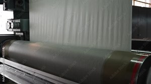 Paper and pulp mill. Process of various paper products manufacturing indoors. An empty quiet industrial wallpaper and paint factory with giant industrial wall paper rolling machines.