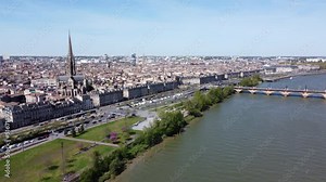 Basilica Of St. Michael And Pont de Pierre By The Garonne River In Bordeaux, France On A Sunny Day. wide aerial