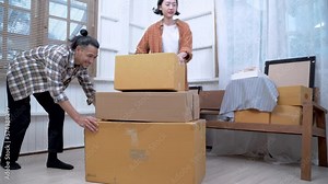 couple asian people holding big paper box together, they will decorating and cleaning home, they move to a new residence. Happy couple having fun with cardboard boxes while moving into new home. Stock Video