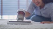 4k footage Close up of Woman using vacuum cleaner on bed at home