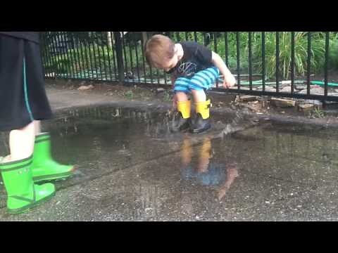 Kids splashing in puddles, in rainboots
