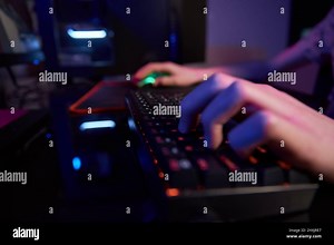 Professional gamer play computer video game in dark room, use neon colored rgb mechanical keyboard, place for cybersport gaming Stock Photo - Alamy