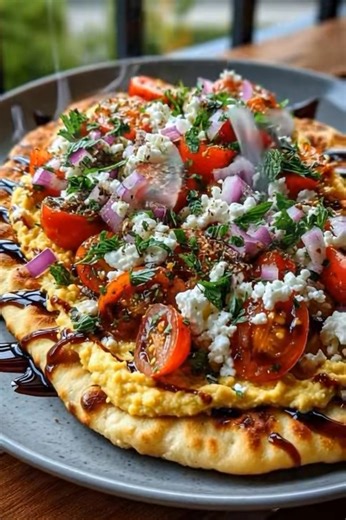 Easy Mediterranean Flatbread with Fresh Herbs & Hummus Ingredients 4 small flatbreads or naan 1/2 cup hummus (classic or flavored) 1 tbsp olive oil 1/2 cup cherry tomatoes, halved 1/4 cup cucumber, diced 1/4 cup red onion, thinly sliced 1/4 cup Kalamata olives, sliced 2 tbsp fresh parsley, chopped 2 tbsp fresh mint, chopped 1/4 cup crumbled feta cheese Optional: drizzle of balsamic glaze Directions Warm Flatbreads: Preheat oven to 375°F (190°C). Warm flatbreads for 3–5 minutes until soft and pli