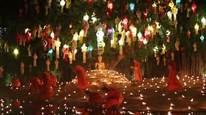 Monk light a candles to pray the Buddha