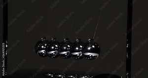 Looped motion Newton Pendulum. Loop. Steel shiny balls suspended on a dark background. They interact with each other, transferring the force of impact