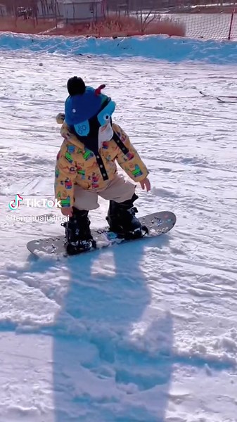 Toddler Learning to Snowboard on a Winter Day