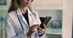 Cropped view female doctor using smartphone at workplace, lead on-line chat, use messaging apps to communicate with patients, answer questions, provide medical advice. Telemedicine application usage