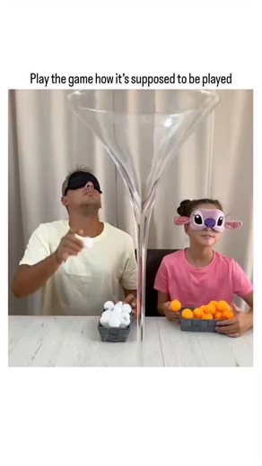 buzz__decode on Instagram: "The post features a viral video of a blindfolded couple competing to scoop ping-pong balls into a martini glass using orange-filled baskets and controllers for a €100 prize; the woman cheats by hand-guiding the balls to win, while her partner notices but laughs it off, captioned "Play the game how it’s supposed to be played" for humorous effect. Posted on December 27, 2025, by @queenof99lol (bio: "don’t trust me"), it garnered over 4.7 million views, 2,100 likes, and 