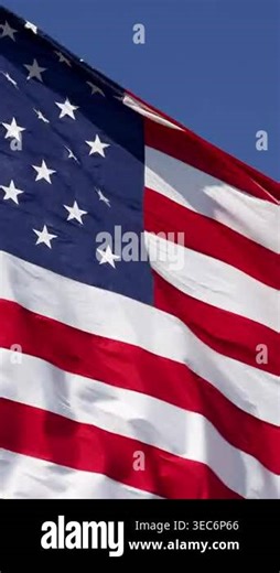 Vertical 4K slow motion American flag waving in the wind gracefully in close-up with bold red, white, & blue detail. Ideal for themes of patriotism, freedom, national pride, remembrance, government, military, holidays, and American identity Stock Video Footage - Alamy