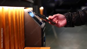 woman paying with her smart phone at an ATM machine