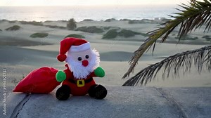 Cute Santa Claus on the beach with palm trees. Celebrating Christmas and New Year in tourist resorts on an island with tropical climate concepts