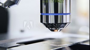 Extreme close up of scientist s hand in a green glove putting liquid under a microscope and adjusting it. Locked down real time close up shot