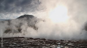 Spring with natural thermal water produces hot steam at sunrise at the famous El Tatio geyser valley at 4320 meters above sea level, Chile.