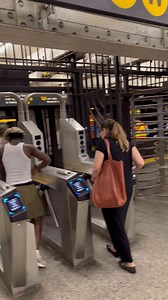 People Navigating Subway Turnstiles in a Bustling City Station