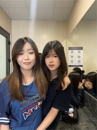 Young Women Taking Playful Selfies in a Restroom