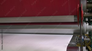 Close-up view of paper roll mechanism of professional wide format printer with white paper loaded inside. Blank paper roll in large printer format inkjet machine for industrial business.