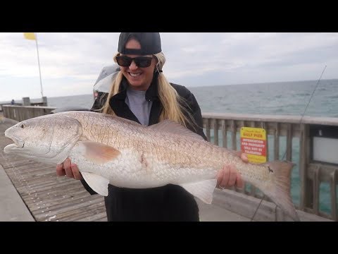 Fisherwoman catches a big redfish during saltwater harvest trip