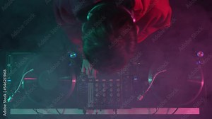 Dj plays music on party in night club, filmed directly from above. 4k stock video of disc jockey playing set on stage. Disk jokey mixing musical tracks with sound mixer and turntables Stock Video