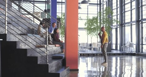 clip-4017906573-african-american-man-presenting-using-microphone-atrium