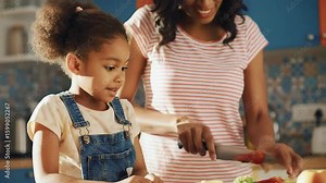 Mother and daughter cooking together in the kitchen at home